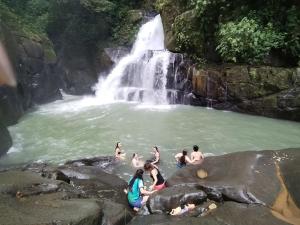 a group of people swimming in a waterfall at La Ceiba Biolgical Reserve in Platanillo