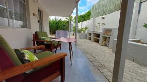 Un patio con una mesa y sillas en un edificio. en The Royal Hilltop, en Riebeek-Kasteel