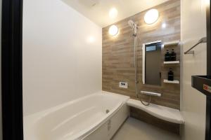 Baño blanco con bañera y espejo en 北の杜ピリカ輪厚, en Kitahiroshima 12 fotos más