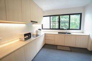 a kitchen with white cabinets and a sink and a window at K5 Seaview Hillside 3BR and 1 Staff Quarter in Ban Ko Kok