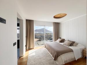 Un dormitorio blanco con una cama y una ventana grande. en Chalet Cueva del Sol, en Tahiche 60 fotos más
