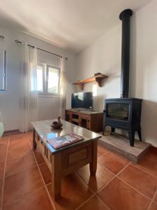 a living room with a fireplace and a tv at Las Palomas in Benamahoma