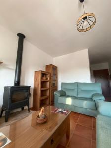 a living room with a blue couch and a stove at Las Palomas in Benamahoma