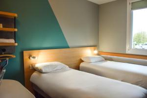 a room with two beds and a window at ibis budget Rodez in Rodez
