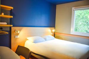a bedroom with a white bed and a window at ibis budget Rodez in Rodez