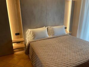 a bedroom with a bed with white sheets and pillows at Hotel Villa Rosa in Sirmione +83 photos