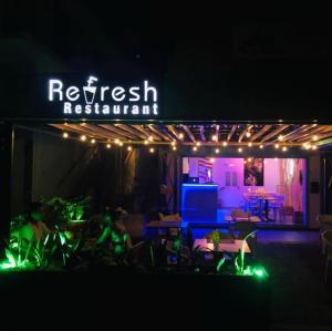 a restaurant with lights and tables and chairs at night at Refresh Holidays in Mont Choisy