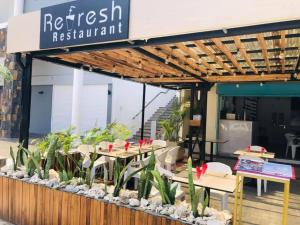 a restaurant with tables and plants in front of it at Refresh Holidays in Mont Choisy +105 photos
