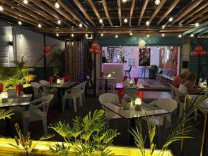 a restaurant with tables and chairs in a room with plants at Refresh Holidays in Mont Choisy