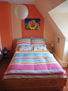 een slaapkamer met een groot bed met een oranje muur bij Ferienwohnung Sonnenblume in Leer