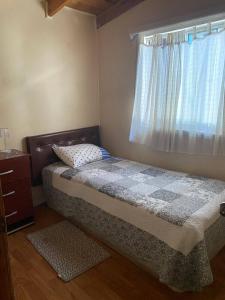 a small bedroom with a bed and a window at Cabañas Casa Blanca in Valdivia +8 photos