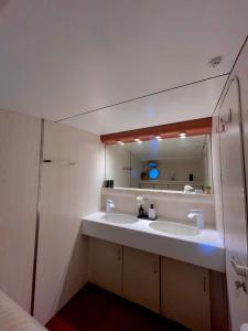 une salle de bain avec deux lavabos et un grand miroir dans l'établissement Yacht idéalement situé au coeur du Vieux-Port, à Marseille