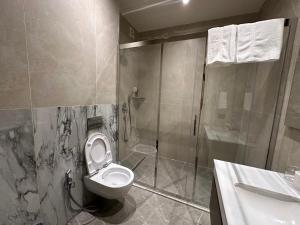 une salle de bain avec toilettes et douche dans l'établissement sea breeze park residences, à Mekhrably