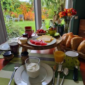 a table topped with plates of food and bread at B&B Even Heukelom - Kamer met Tuin in Afferden