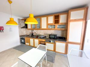 a kitchen with wooden cabinets and white tables and chairs at Casa da Alagoinha by Umbral in Vila Nova de Milfontes +24 photos
