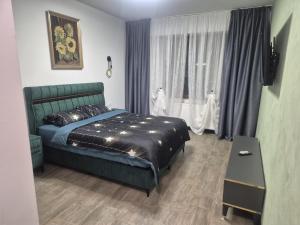 a bedroom with a green bed and a window at Carul cu Flori in Craiova
