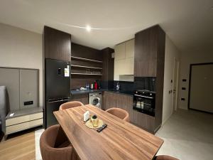 a kitchen with a wooden table and some chairs at sea breeze park residences in Mekhrably
