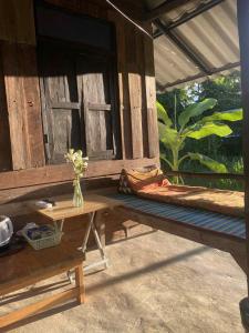 une véranda en bois avec un banc et une fenêtre dans l'établissement Banana garden, à Pai