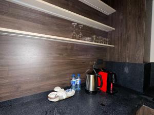 a kitchen counter with a coffee pot and bottles of water at sea breeze park residences in Mekhrably