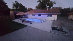 einen Pool mit einem Picknicktisch und einem Sonnenschirm in der Unterkunft Quilleret in Haut-Mauco