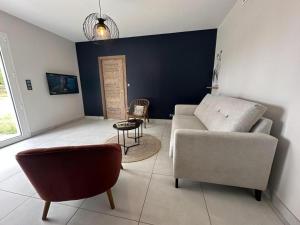 ein Wohnzimmer mit einer Couch und einem Sessel in der Unterkunft Quilleret in Haut-Mauco