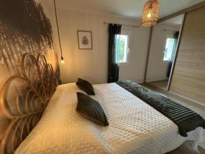 ein Schlafzimmer mit einem großen Bett mit schwarzen Kissen in der Unterkunft Quilleret in Haut-Mauco + 24 Fotos