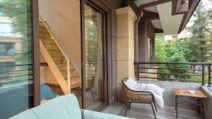 a balcony with a chair and a stair case at Heinemanns Guest House With Jacuzzi Local Family vibes in Baoguosi