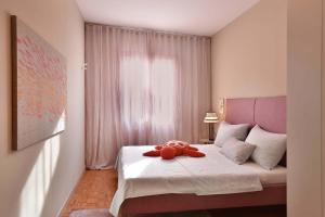 a stuffed animal sitting on a bed in a bedroom at Refugium Serenitas - Boutique Apartment with Garden Terrace in Gargnano