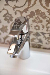 a chrome bathroom faucet on a bathroom sink at Refugium Serenitas - Boutique Apartment with Garden Terrace in Gargnano
