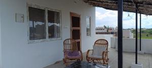 three chairs sitting on the porch of a house at Beverly Dinesh Homestay in Tiruvannāmalai +7 photos