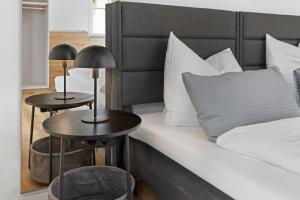 - une chambre avec un lit et 2 tables de chevet dans l'établissement BALANCED Münsing Apartments, vollausgestatte Ferienwohnungen Nähe Starnberger See, à Münsing