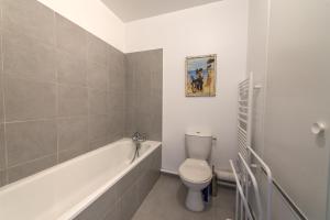 a bathroom with a toilet and a bath tub at Le Studio Rivage - Surplombant le lac in Duingt +12 photos