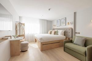 um quarto com uma cama, um sofá e uma cadeira em Wilde Aparthotels Lisbon Liberdade em Lisboa