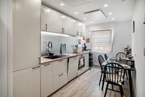 a kitchen with white cabinets and a table with chairs at Ferienwohnung Wittle in Weiler-Simmerberg