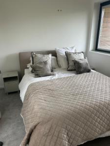 a bedroom with a large bed with pillows at Escape to Infinity! in Guernsey