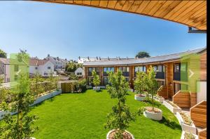 an open courtyard with trees and a building at Escape to Infinity! in Guernsey