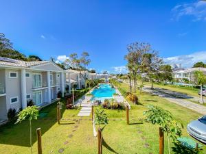 Πισίνα στο ή κοντά στο Casa em condomínio a 200m da praia em Arraial D'ajuda, com 3 suites, sala climatizada, área gourmet privativa, Internet 300MBPS, condomínio com piscinas adulto e infantil, sauna, quadra de beach tenis e portaria 24hrs.