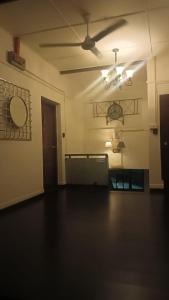 an empty living room with a ceiling fan and a room at Northern Cove Penang in Tanjung Bungah