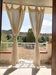 a window with curtains in a room with a view at Da BeA in Villasimius