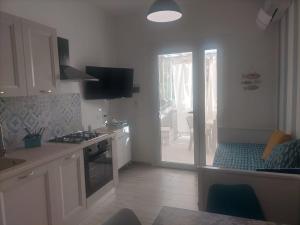 a kitchen with white cabinets and a door to a patio at Da BeA in Villasimius +13 photos