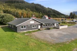 a house in a field with a mountain at Yttersia Base in Senja
