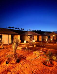un bâtiment au milieu d'un désert la nuit dans l'établissement Melody Desert Camp Merzouga, à Merzouga 70 autres photos