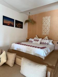 une chambre avec un grand lit dans une pièce dans l'établissement Melody Desert Camp Merzouga, à Merzouga