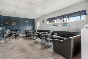 a bar with black leather furniture and bar stools at Yttersia Base in Senja