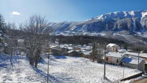 a village in the snow with a mountain in the background at ApartRelax in SantʼEufemia a Maiella