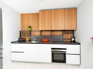 a kitchen with white counters and wooden cabinets at Käpt'n Cook 4 von Appartements & Mehr in Kampen