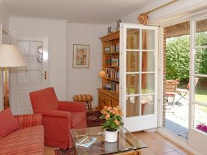 a living room with red chairs and a glass table at Enenhoog Flugente von Appartements & Mehr in Kampen