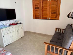 a living room with a couch and a flat screen tv at Casa Alvorada in Flecheiras