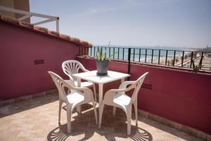un tavolo e sedie su un balcone con vista sull'oceano di Ático con vistas a Port Saplaya