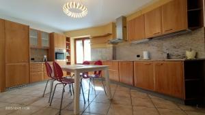 a kitchen with wooden cabinets and a table and chairs at Residenza dentro le mura - 5 min walk to Bernina Express in Tirano +15 photos